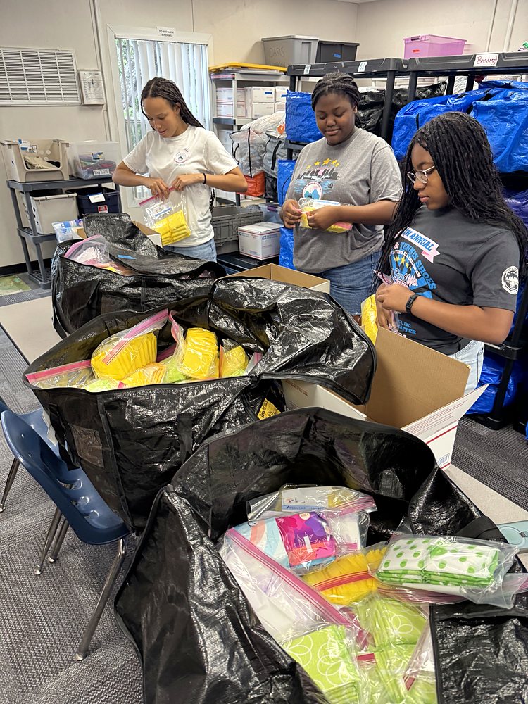 Teen girls packing supplies for students