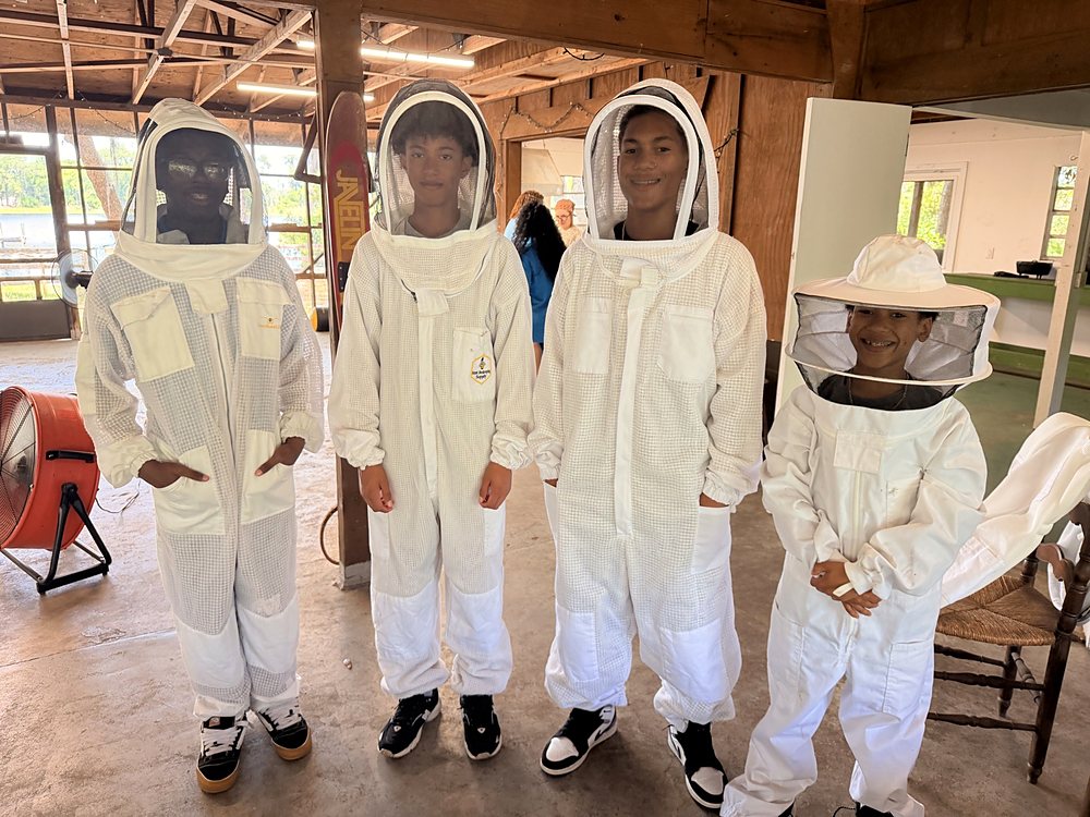 Children in beekeeping suits