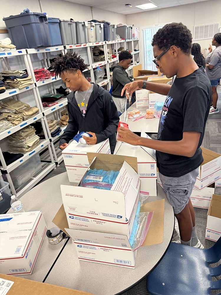 Teens packing boxes of supplies for students